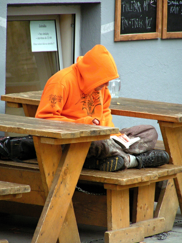Reading Man in Orange Hoodie